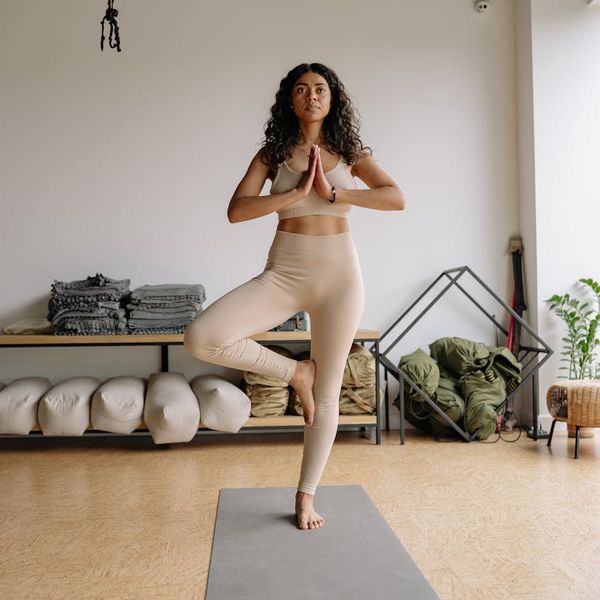 Person balancing on one leg in a serene yoga studio setting.